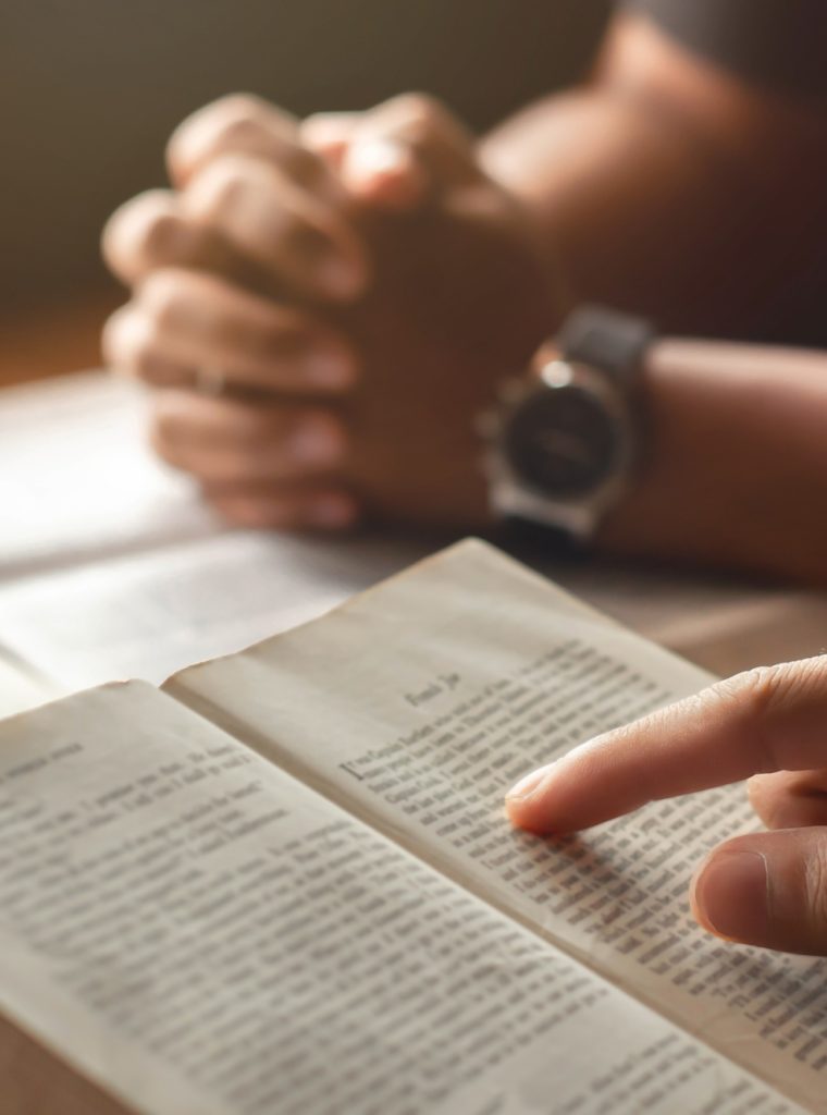 young man reading bible with friends who are praying to God Join the cell group at the church.